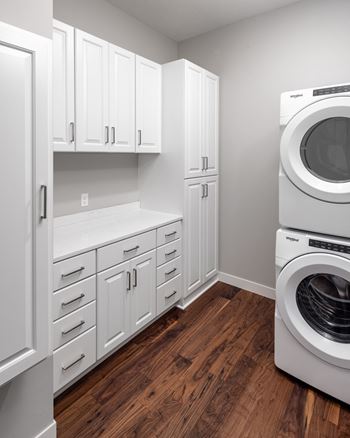 a laundry room with a washer and dryer and white cabinets at Expo, Minneapolis, MN 55414